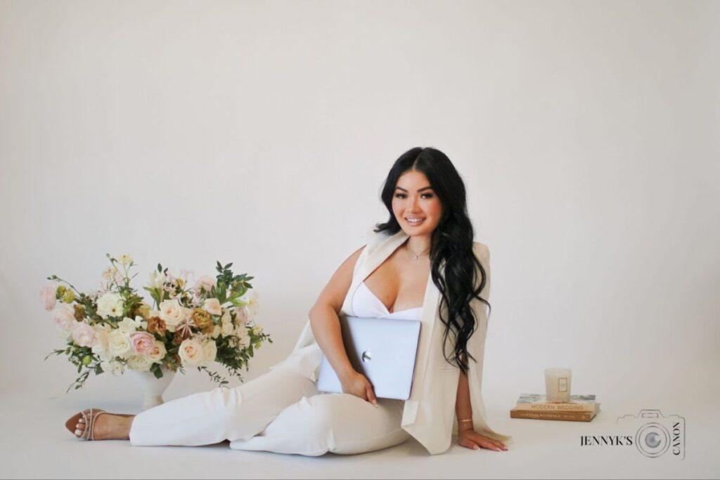 Portrait of a professional wedding planner standing confidently with a laptop in hand, smiling warmly